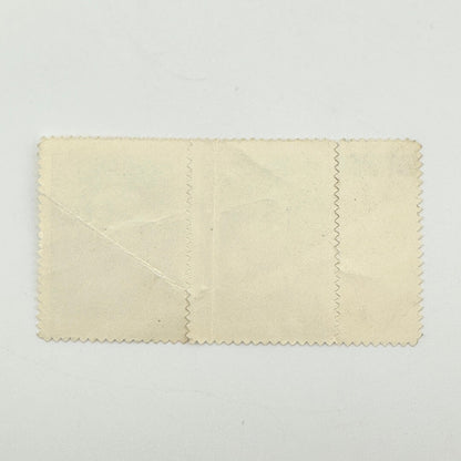 A vintage cream-colored stamp set with scalloped edges, showing signs of age, creases, and wear.