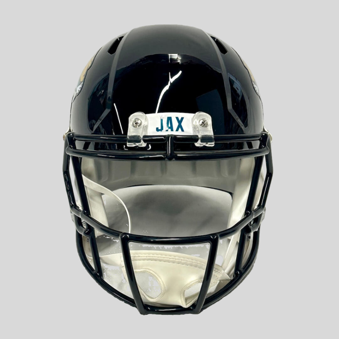 Black football helmet with 'JAX' above. face against gray background.