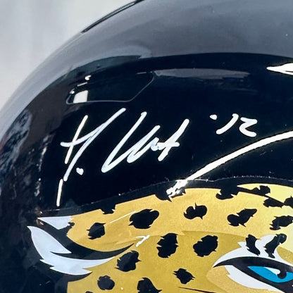 Black helmet with a leopard design and signature on a white background