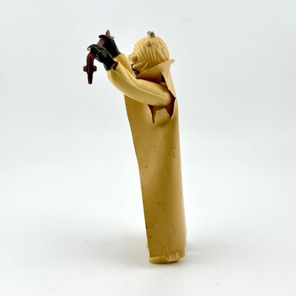 Side view of action figure in beige holding staff on white background. 