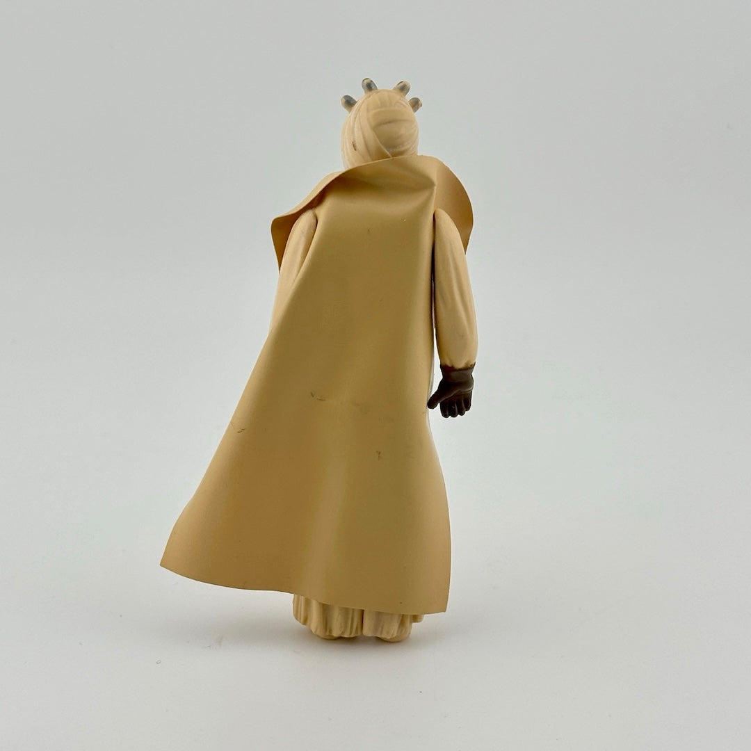 Action figure in all tan, wearing tan cape, brown gloves, brown belt, and tan wrapped face with mouthpiece.