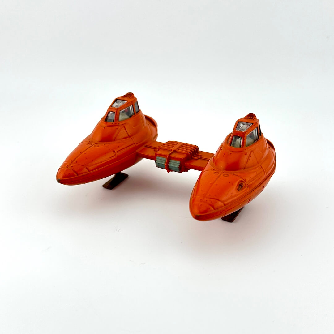 Orange toy spaceship on a white background
