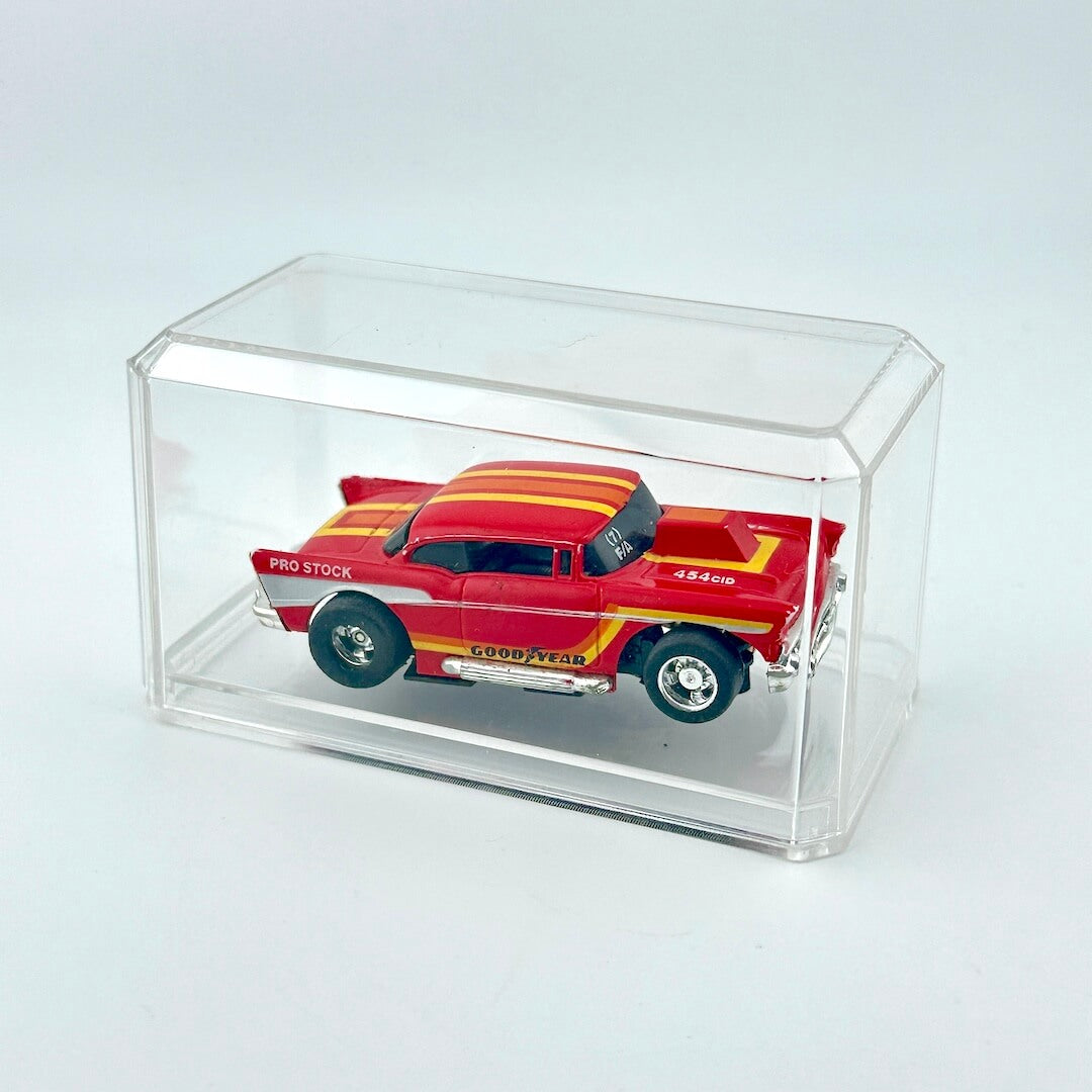 Red and yellow model car in a clear display case on a light gray background