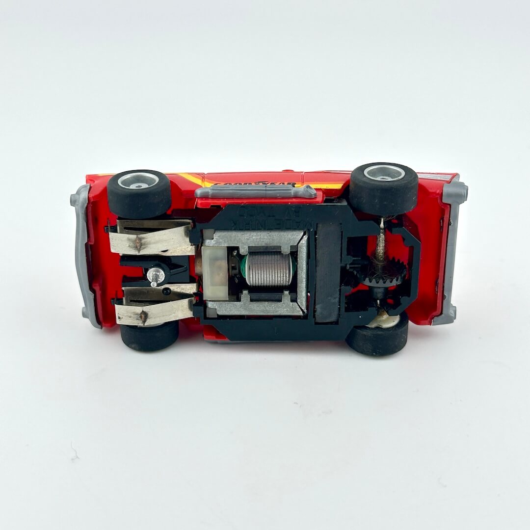 Red toy car with black wheels on a white background