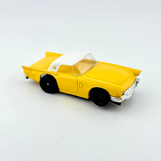 Yellow toy car with a white roof on a light gray background