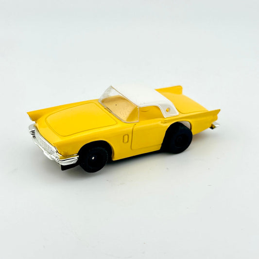 Yellow toy car with white roof on a light gray background