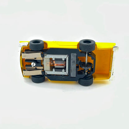 Underside of slot car to show electric components against white background. 
