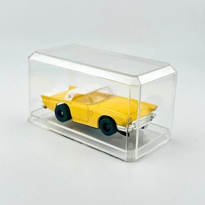 Yellow toy car in a clear display case on a light gray background