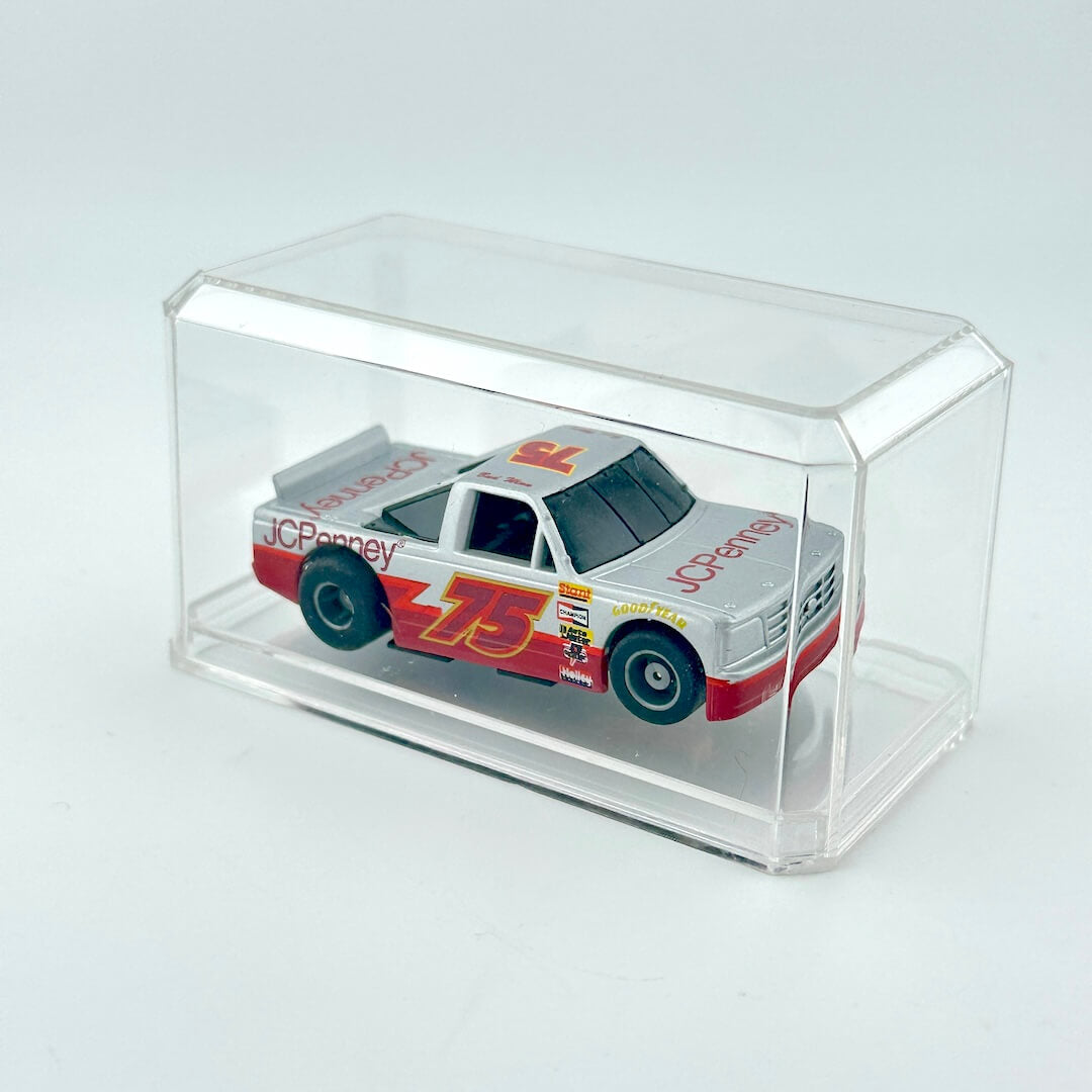 Model truck in a clear display case on a light gray background