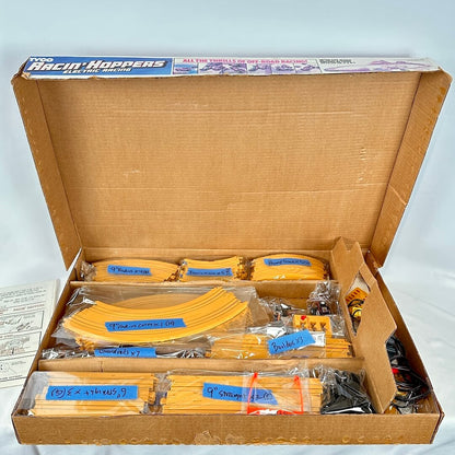 Open box of Racin' Hoppers model race tracks with packaging on a white background