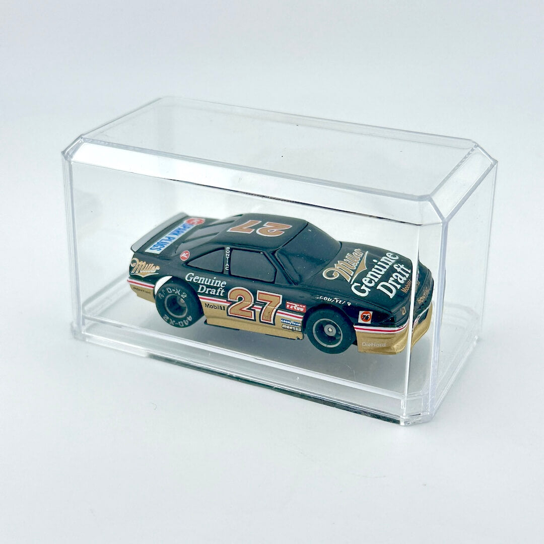 Model car in a clear display case on a white background