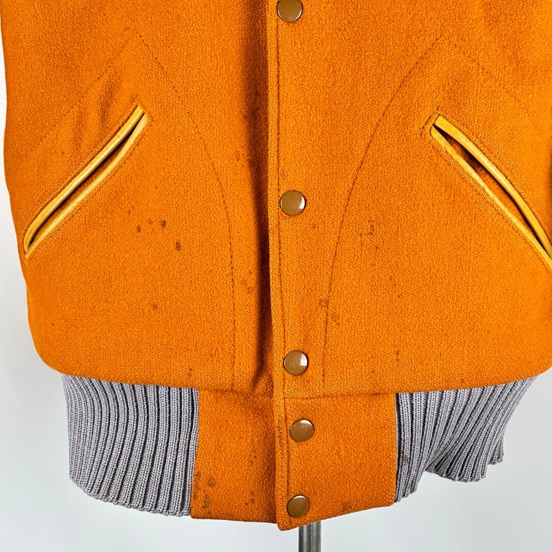 Close up of bottom half of front of jacket. Some staining spattered up to pockets at midsection. 