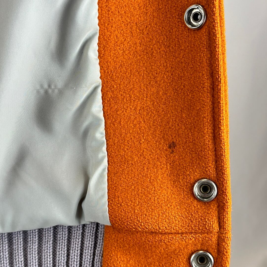 Interior stain just inside by one of the snaps. Liner has light snag in satin.