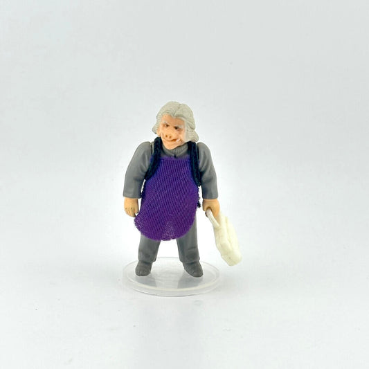 Alien action figure in gray outfit and purple apron holding white briefcase against white background.