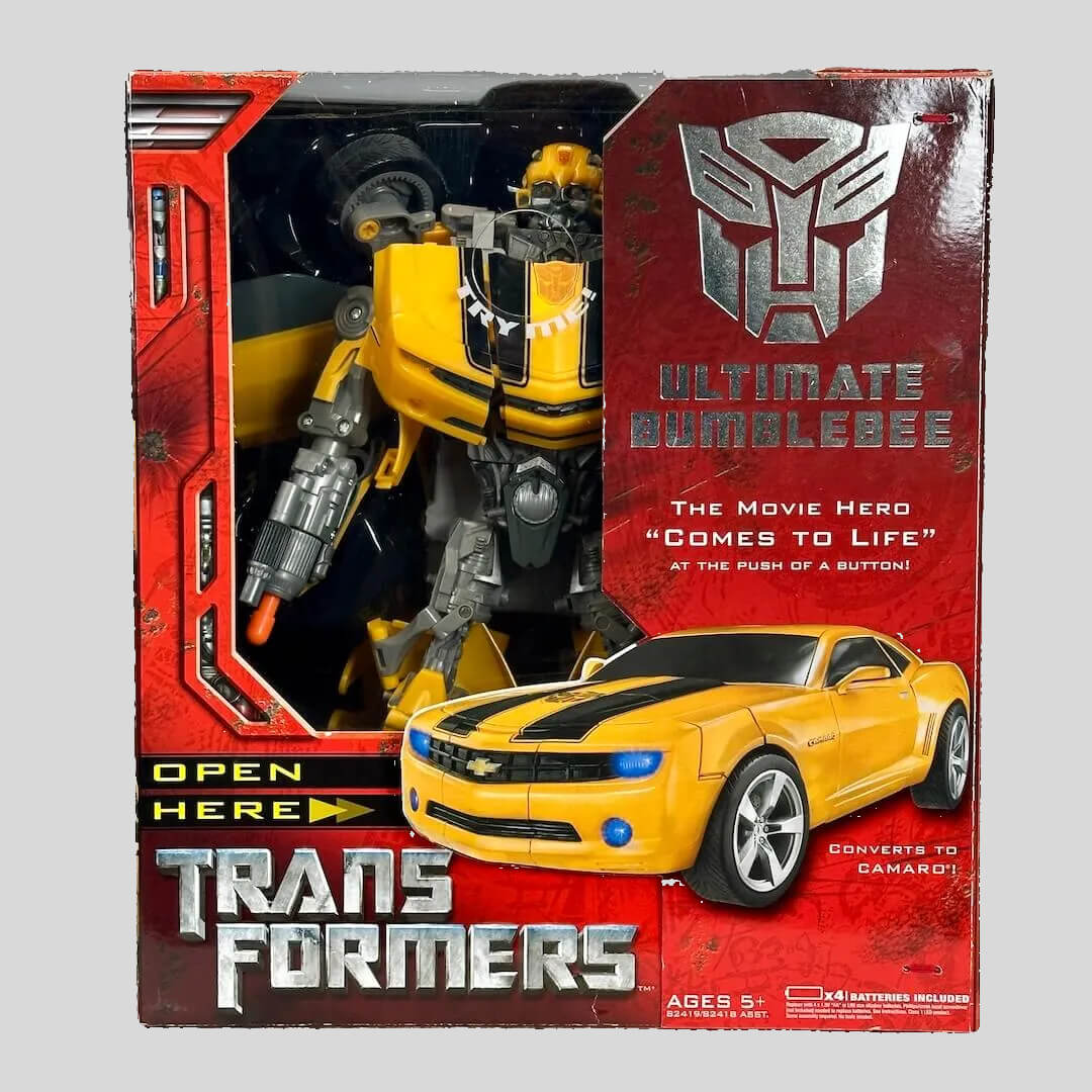 Transformers action figure packaging with yellow and black robot and car, and Autobot logo.