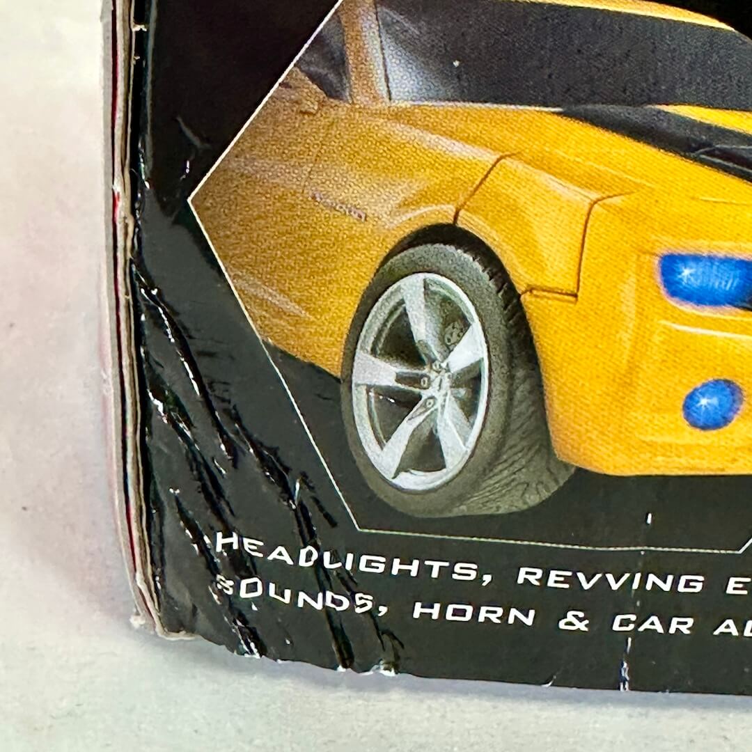 Close-up of a toy car packaging with a yellow car on a white background