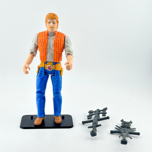 Action figure rin blue pants and orange vest with two accessories against white background.