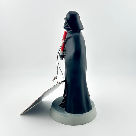 Dark Vader figurine holding a lightsaber on a white background