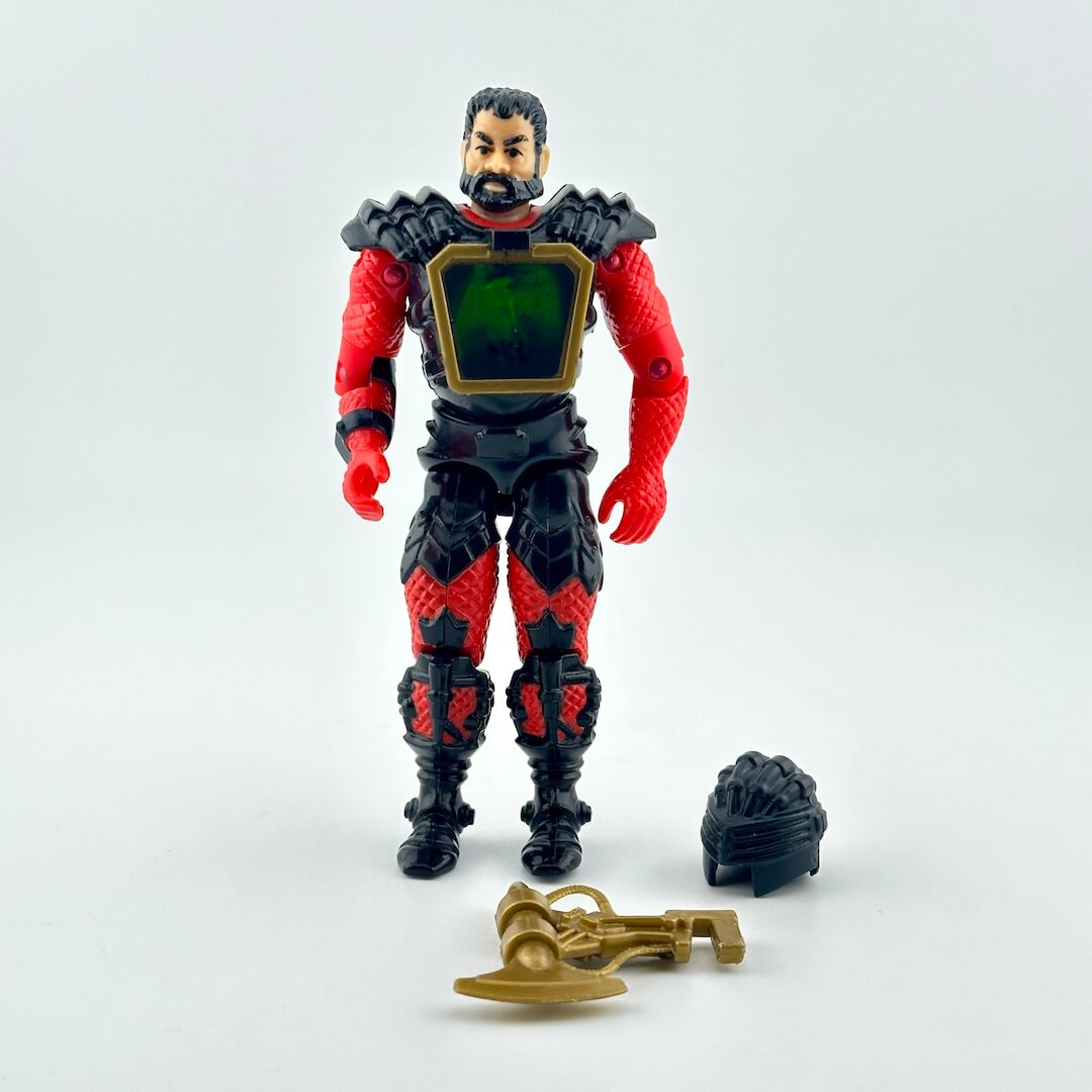 A red and black armored action figure with a green chest panel, shown with two accessories on white background. 
