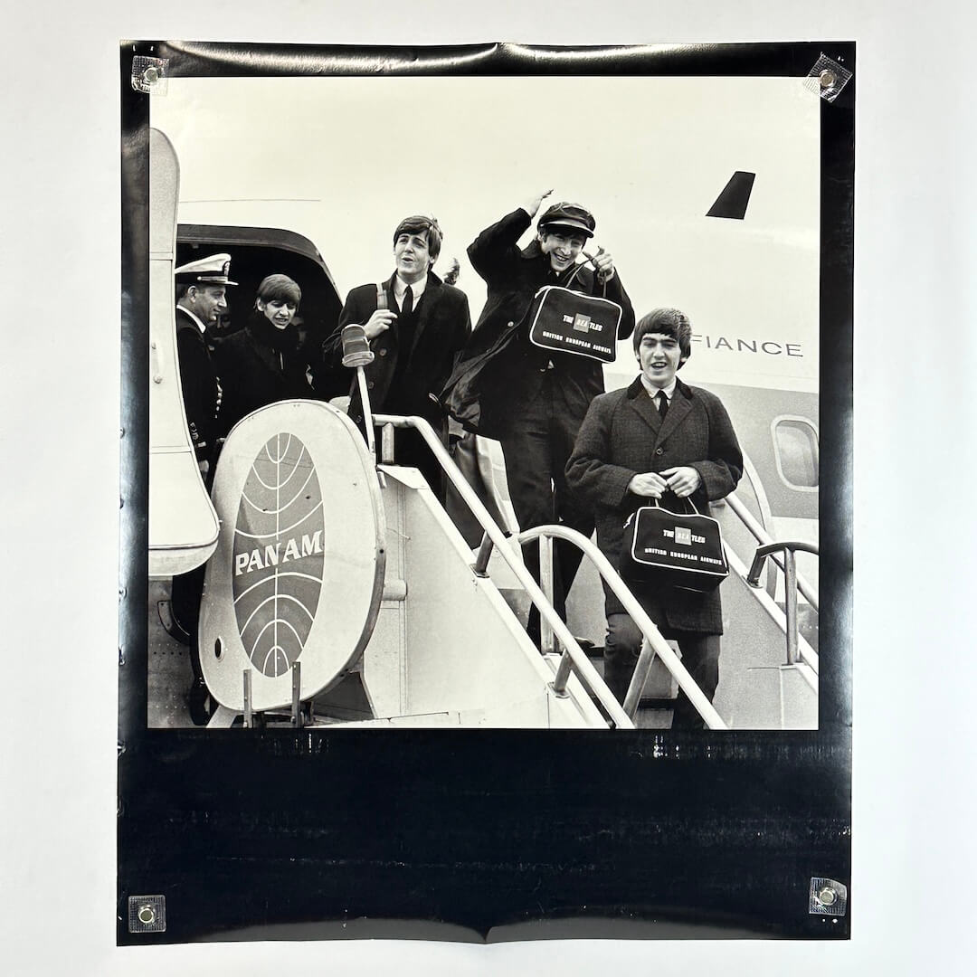 Black and white photograph of a group of men boarding an airplane with Pan Am branding.