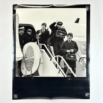Black and white photograph of a group of men boarding an airplane with Pan Am branding.