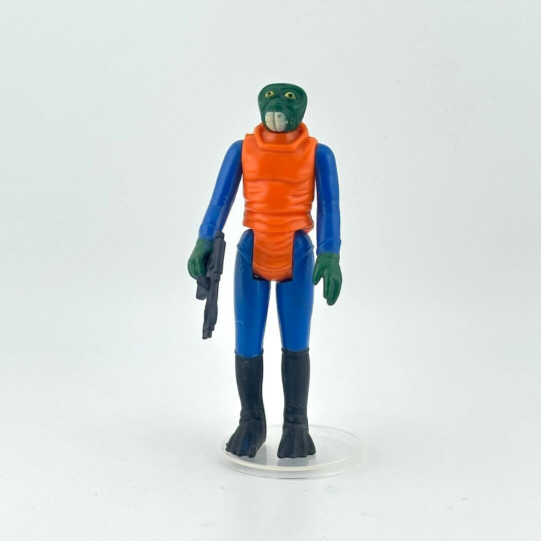 Action figure with green skin, blue suit, and orange vest on a white background