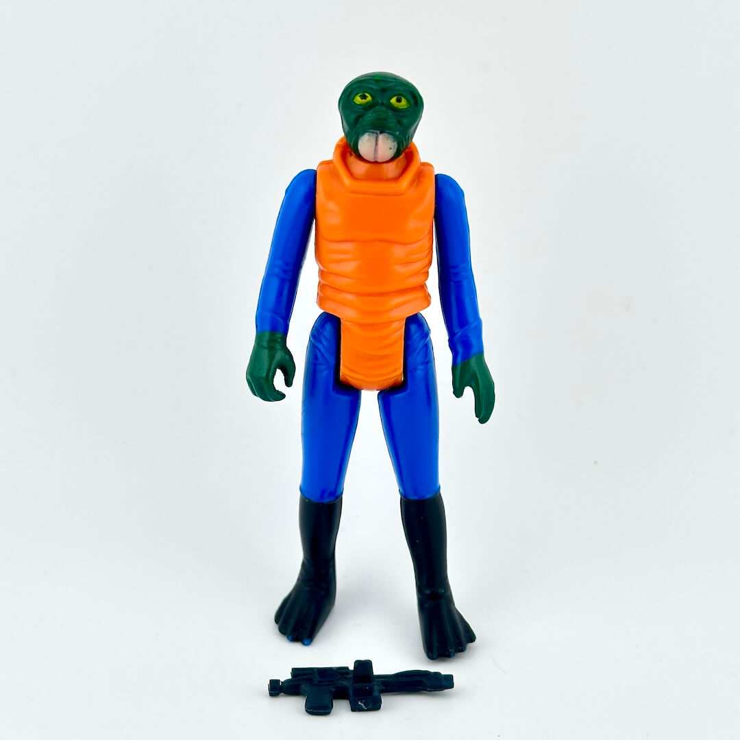 A vintage plastic action figure of a green-skinned alien with blue and orange body with weapon.