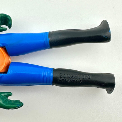 Close-up of a plastic action figure legs to show the COO and copyright information 