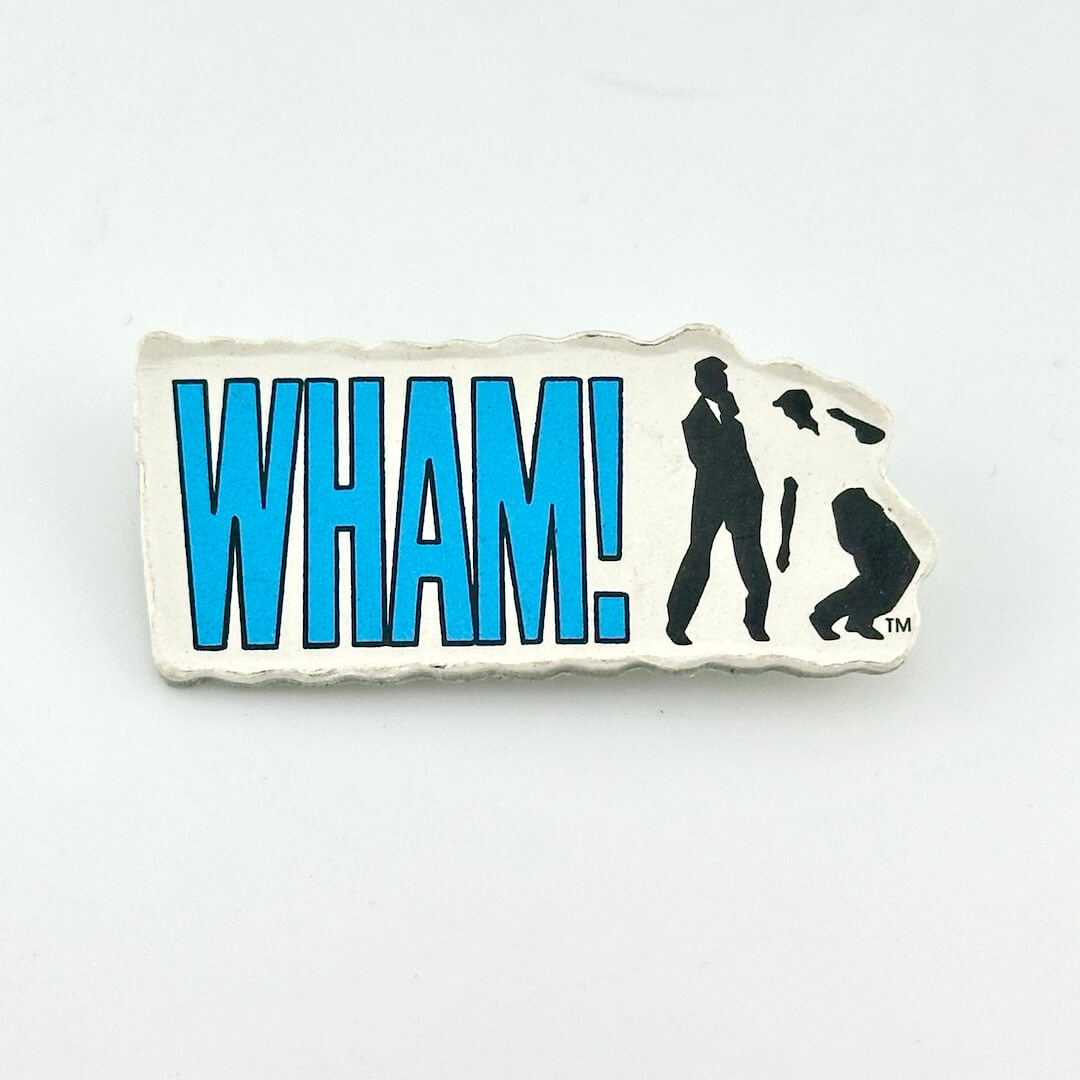 Vintage pin with blue text, "WHAM!" next to two silhouettes dancing. 