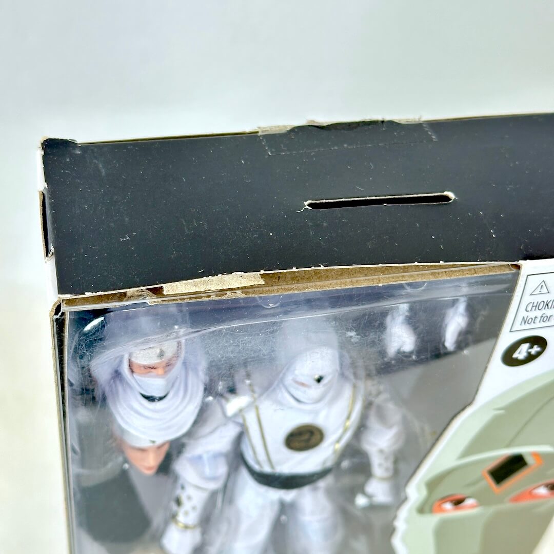 Close-up of top of packaging showing that its been opened and has some wear. 