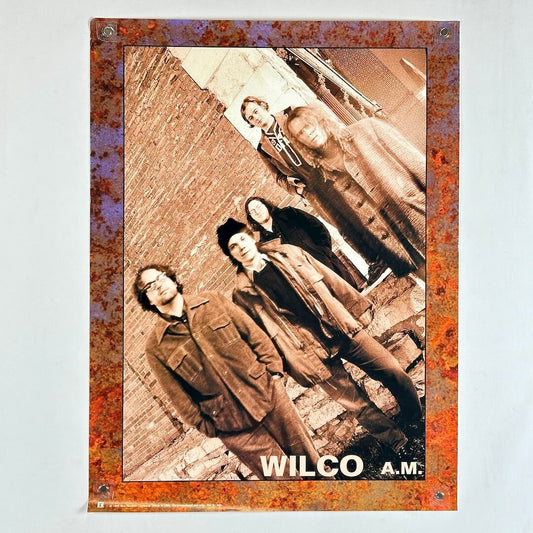 Poster of a band with 'Wilco A.M.' text on a textured border