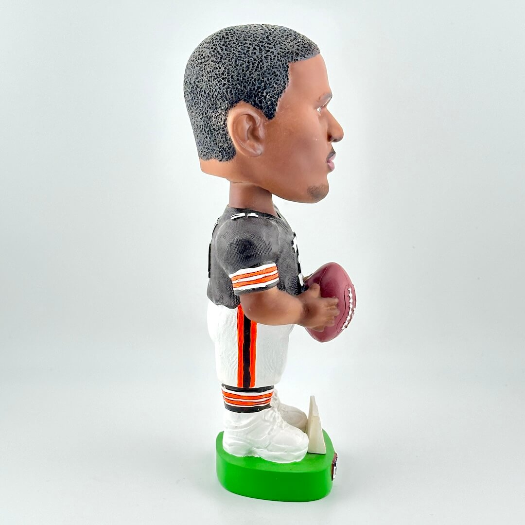 Bobblehead figure of a football player holding a ball on a white background