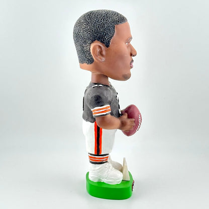 Bobblehead figure of a football player holding a ball on a white background
