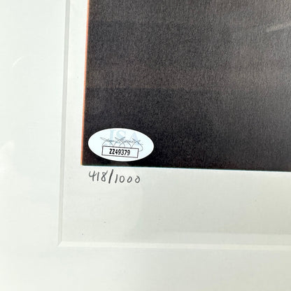 Close-up of a framed artwork with an authentication label on a white background