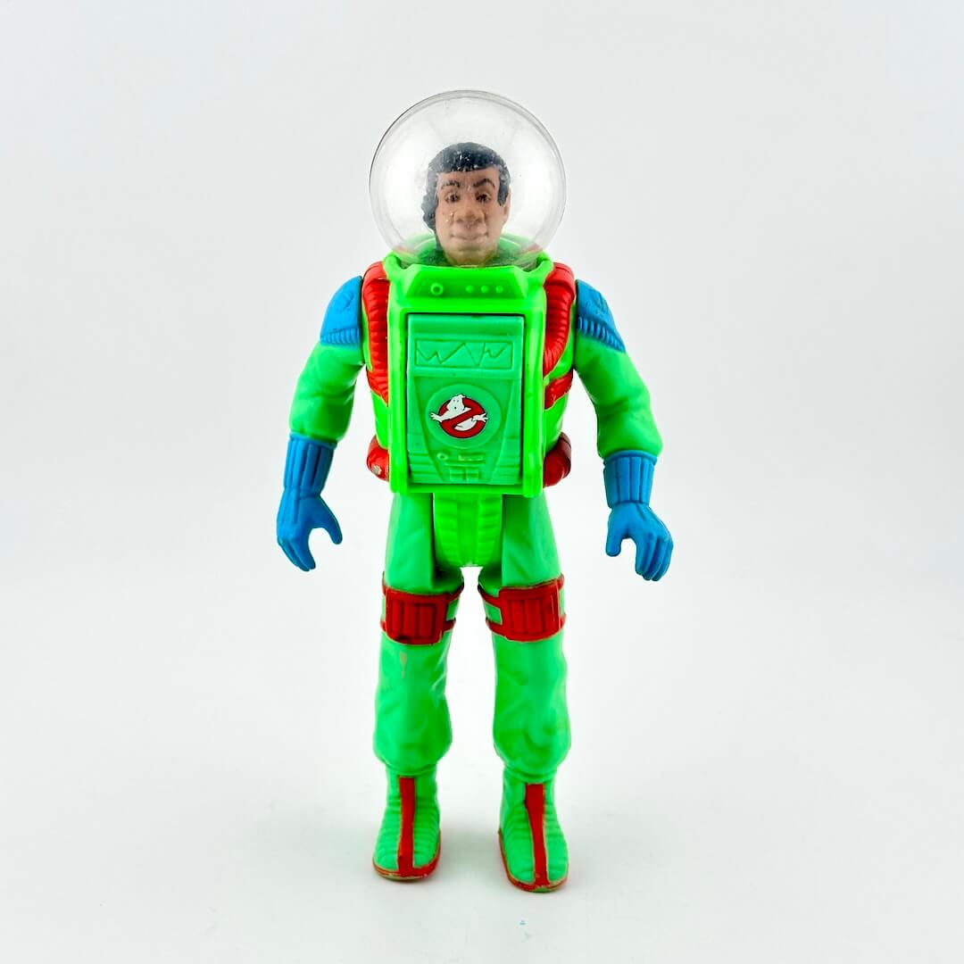 Toy figure in a green astronaut suit with a clear helmet on a white background