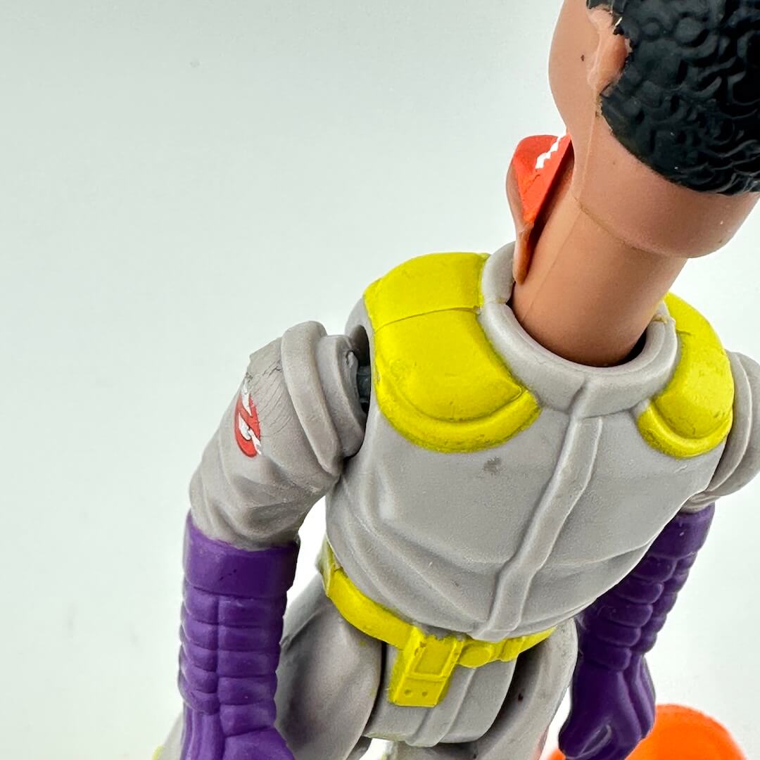 Toy figure with purple sleeves and yellow accents on a white background
