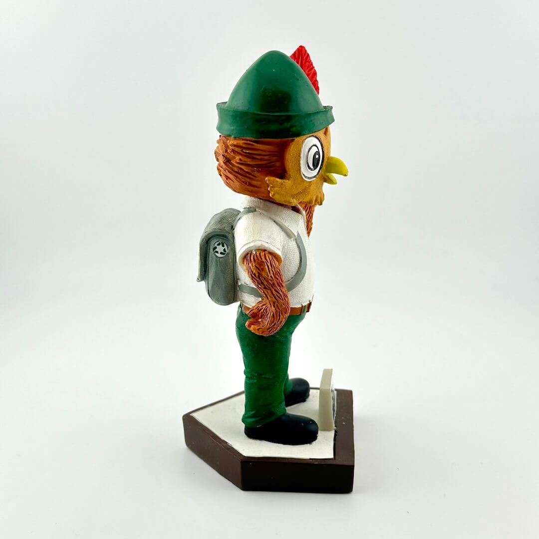 Bobblehead figure of a character with a green hat and backpack on a white background