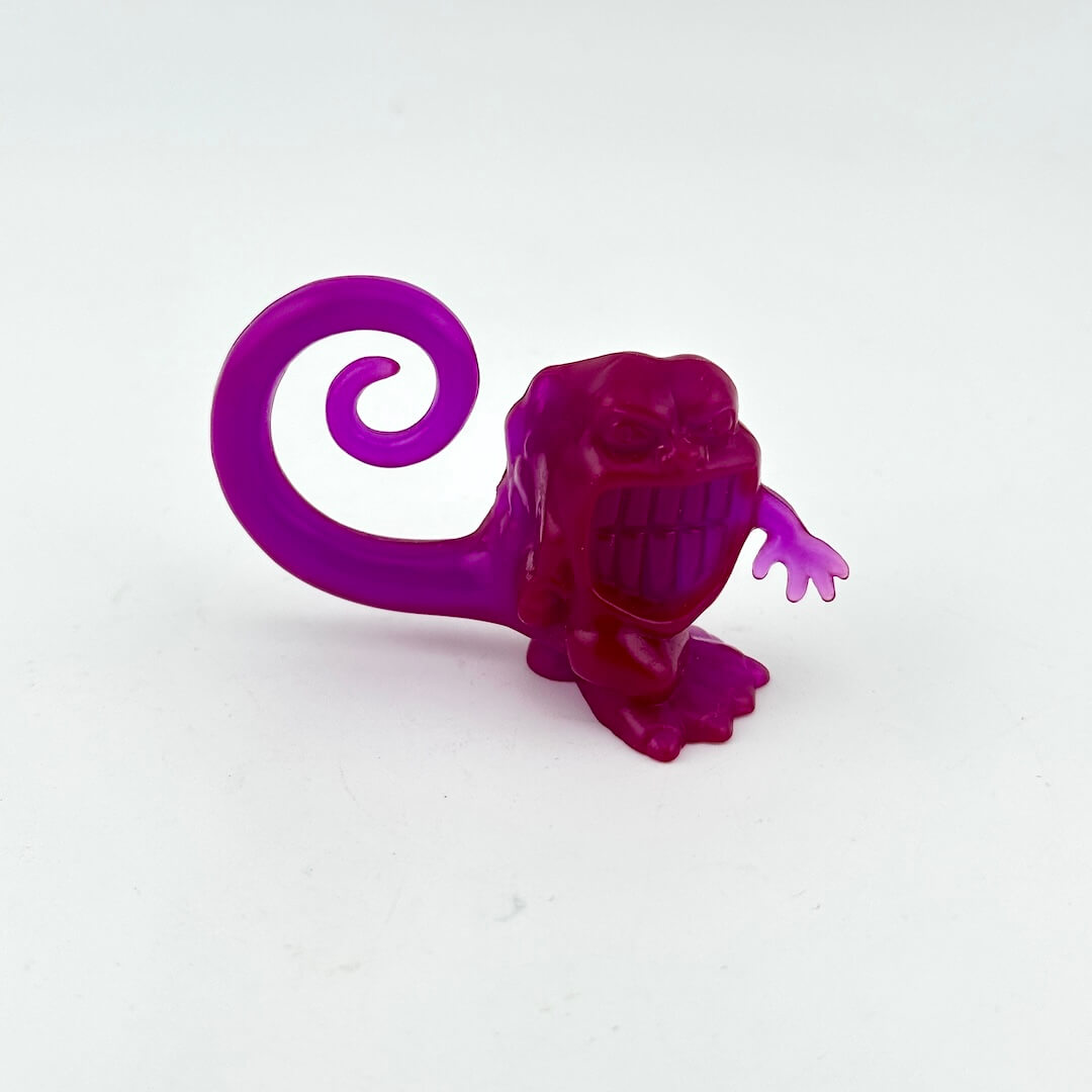 Purple plastic toy figure of a creature on a white background