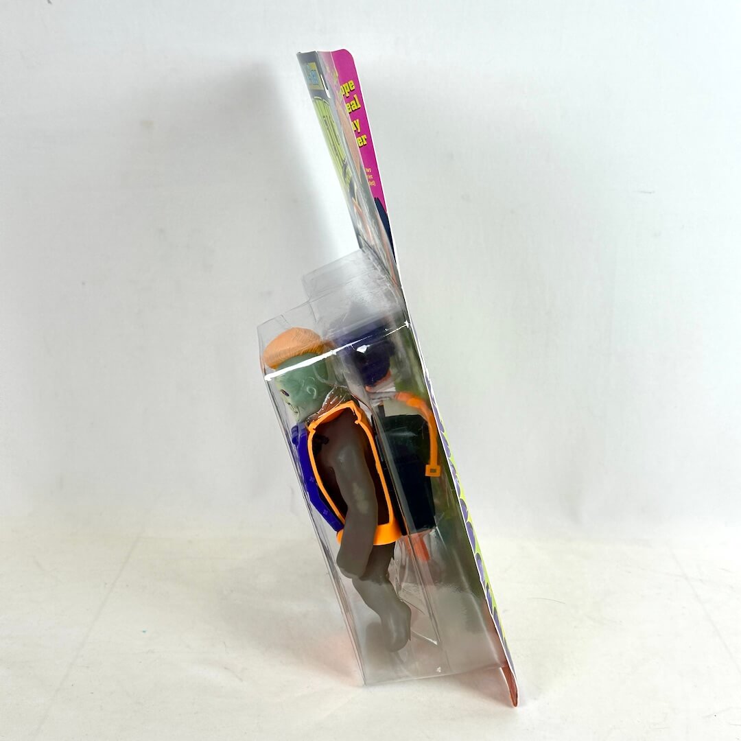 Side view of toy in packaging against white background. 