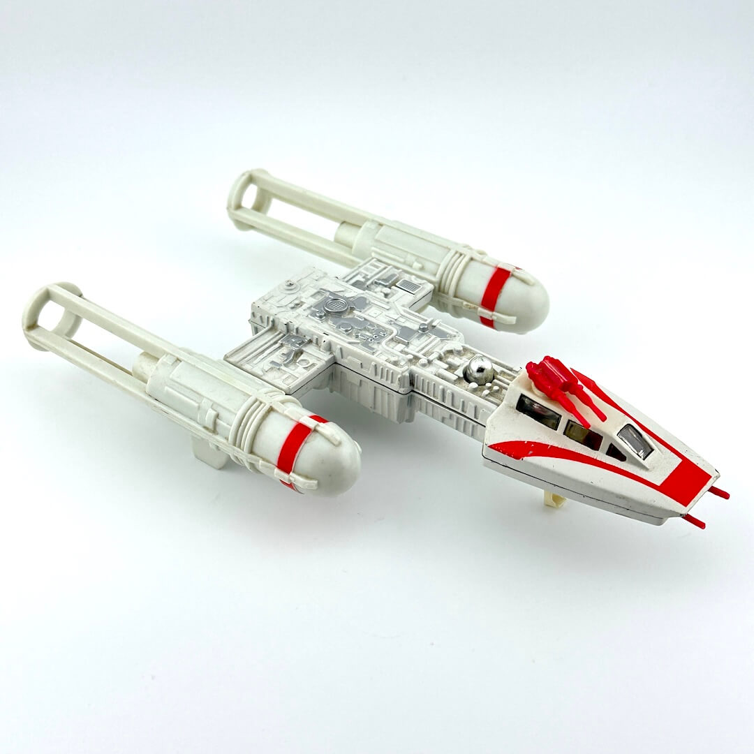 Toy model of a spaceship with red and gray design on a white background