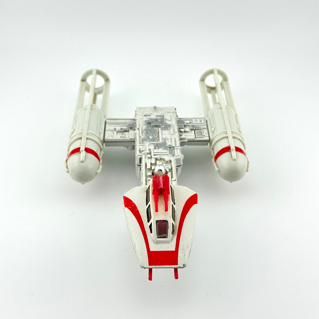 Toy model of a spaceship with red and white design on a white background