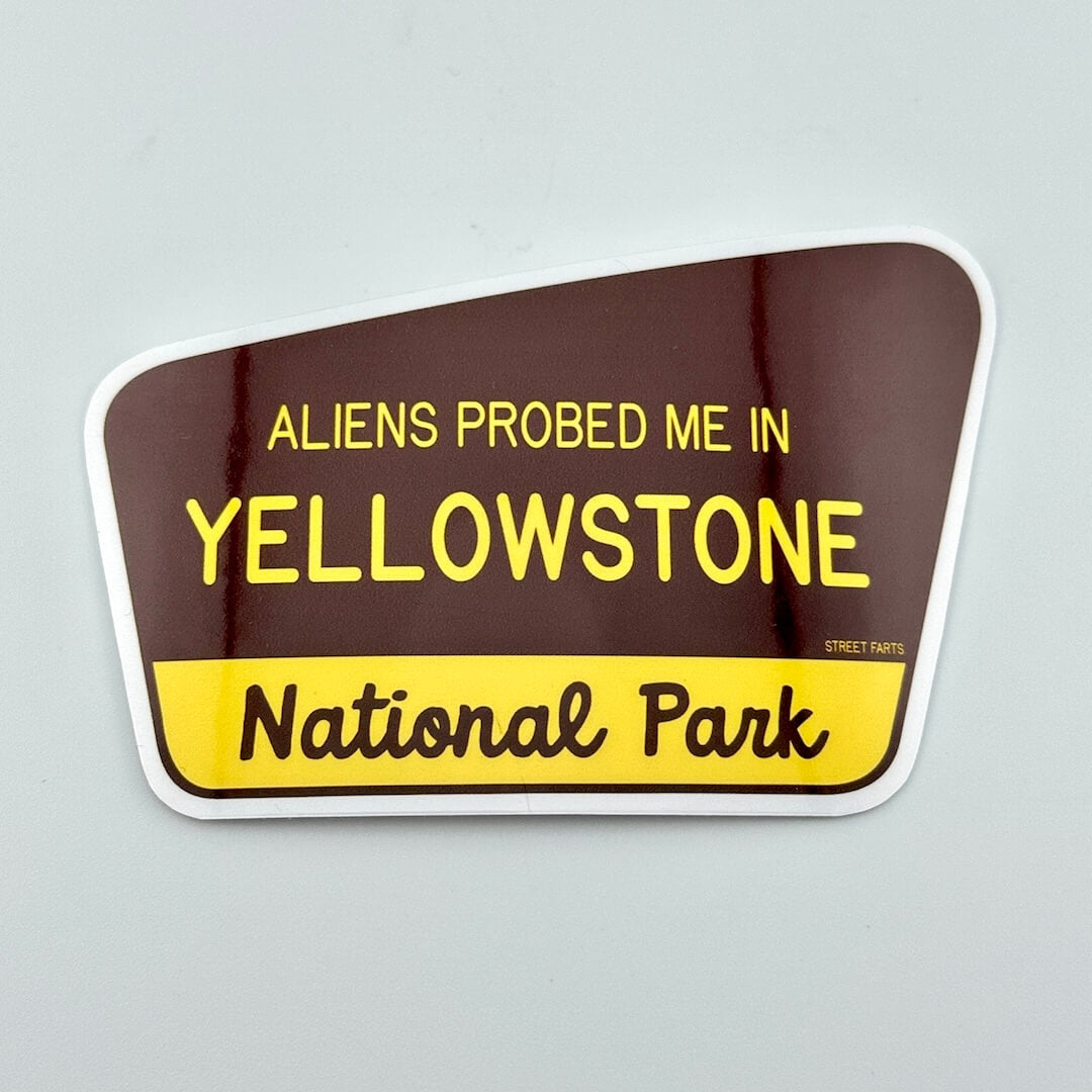 Sticker with text 'ALIENS PROBED ME IN YELLOWSTONE National Park' on a gray background