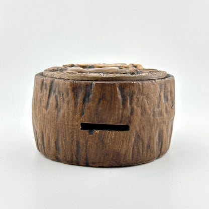 Top of coin bank made to look like wooden cross section.