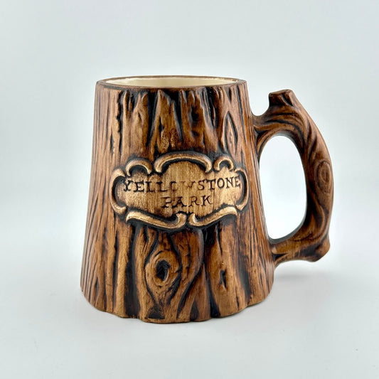 Wooden-textured mug with 'Yellowstone Park' engraving on a light gray background