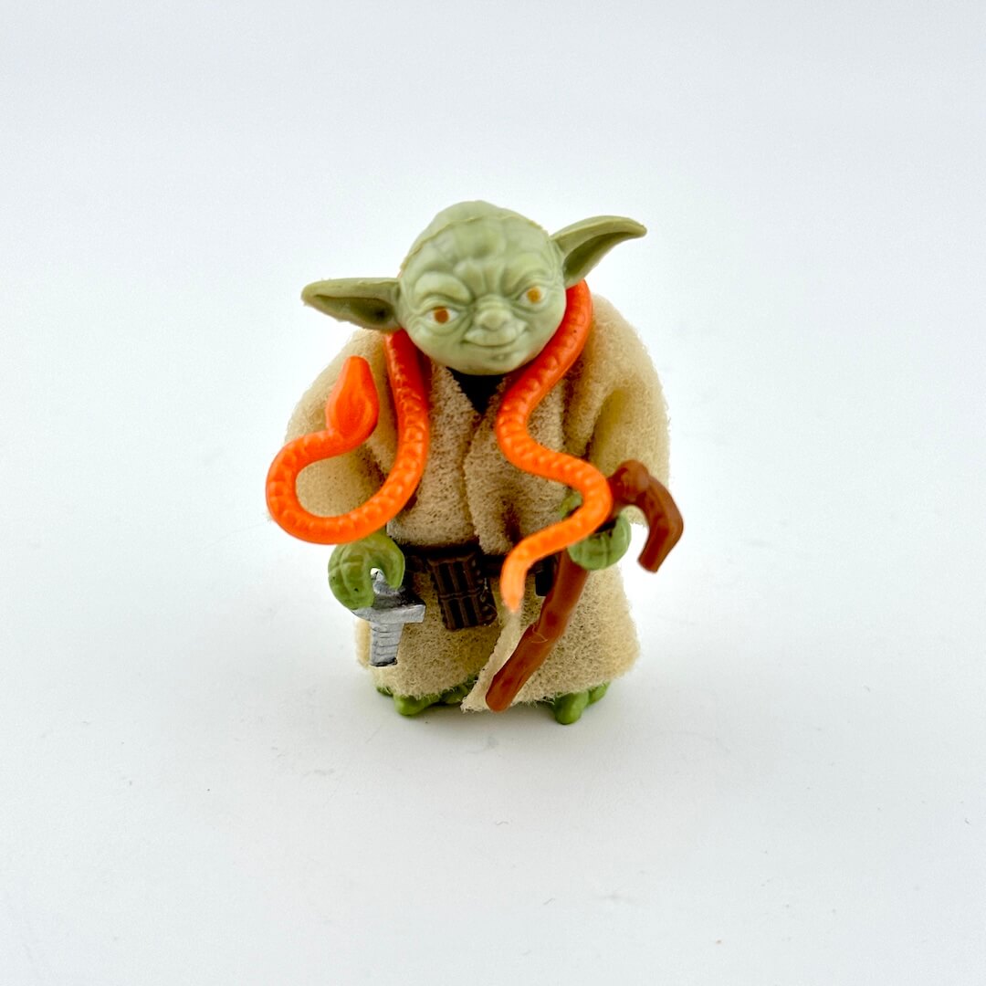 Yoda action figure with accessories on white background.