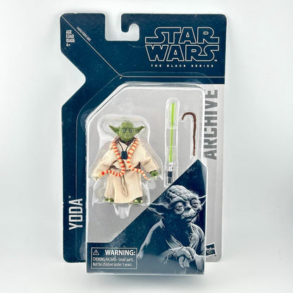 Star Wars The Black Series Yoda action figure in its original blister card packaging, featuring a green lightsaber accessory.