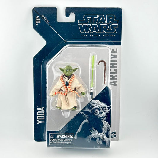 Star Wars The Black Series Yoda action figure in its original blister card packaging, featuring a green lightsaber accessory.
