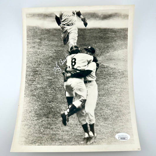 Black and white photo of baseball players celebrating on a field, signed by a player.