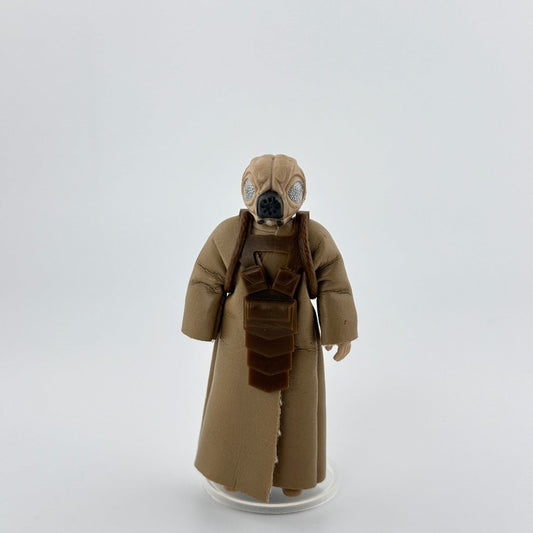 Image of 3.5 inch action figure in beige cloak, brown utility bag on chest, silver insect-like eyes, & black machine mouth