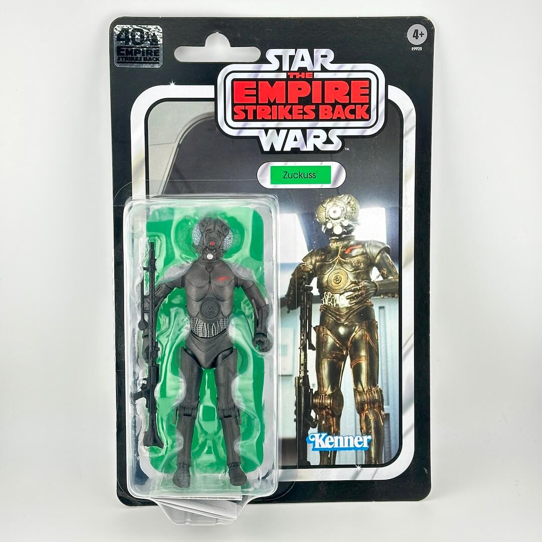 Star Wars action figure in original blister packaging with retro-style card back; figure is black robot-like with accessory. 
